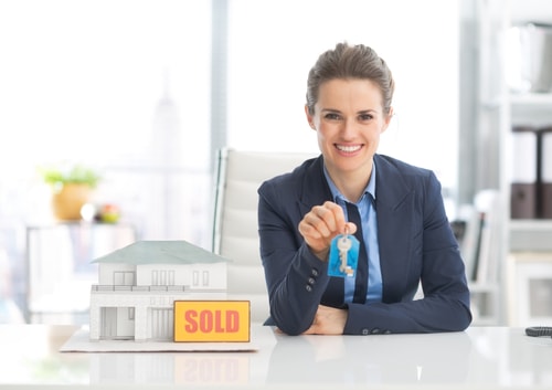 Happy realtor woman showing keys